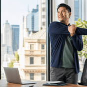 Back-to-routine tips: office professional stretching during an August workday in Midtown Manhattan